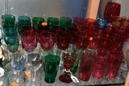 A COLLECTION OF COLOURED DRINKING GLASSES, to include a single ruby etched glass with rough pontil