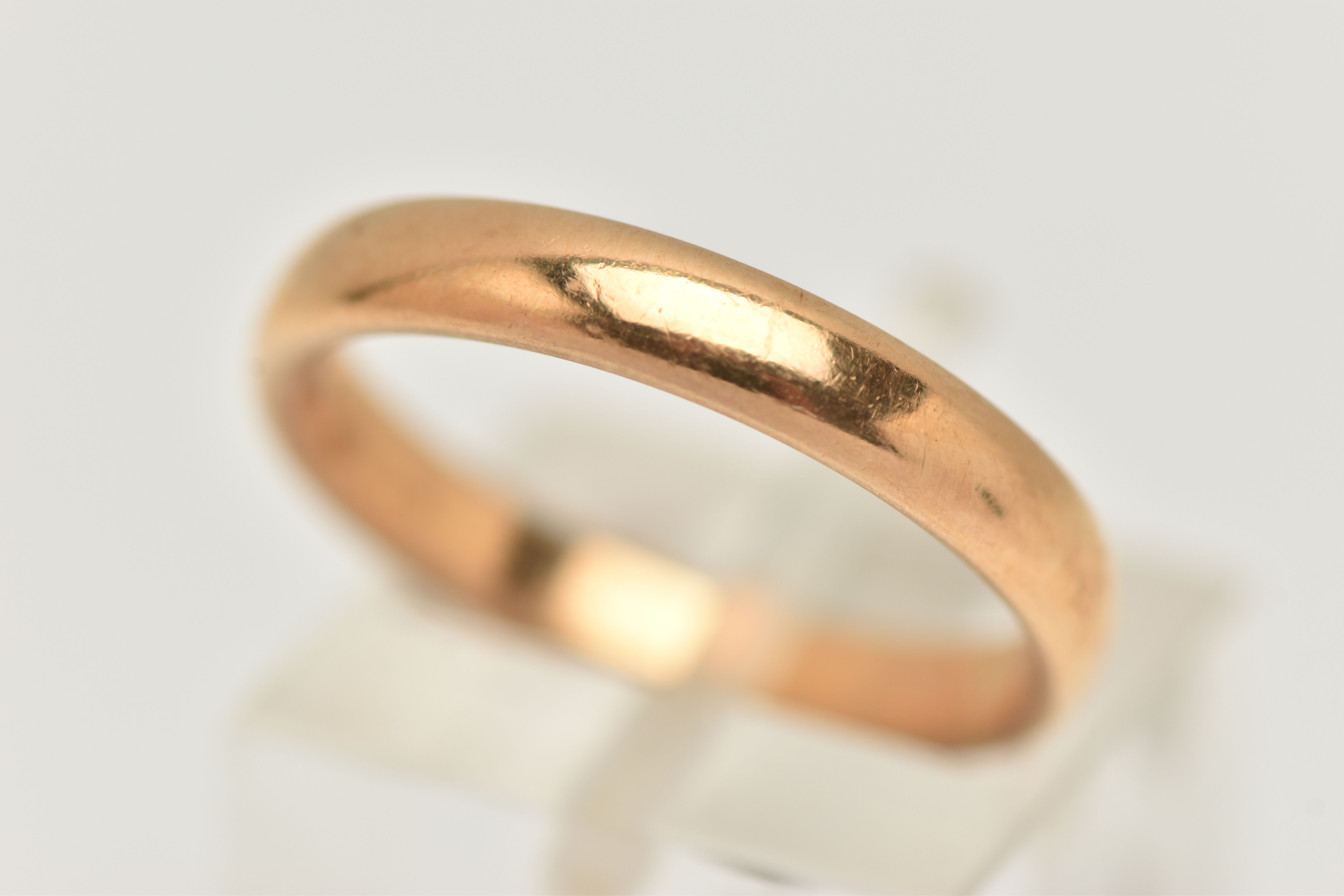 A YELLOW METAL BAND RING, polished band, unmarked, ring size N 1/2, approximate gross weight 4.8