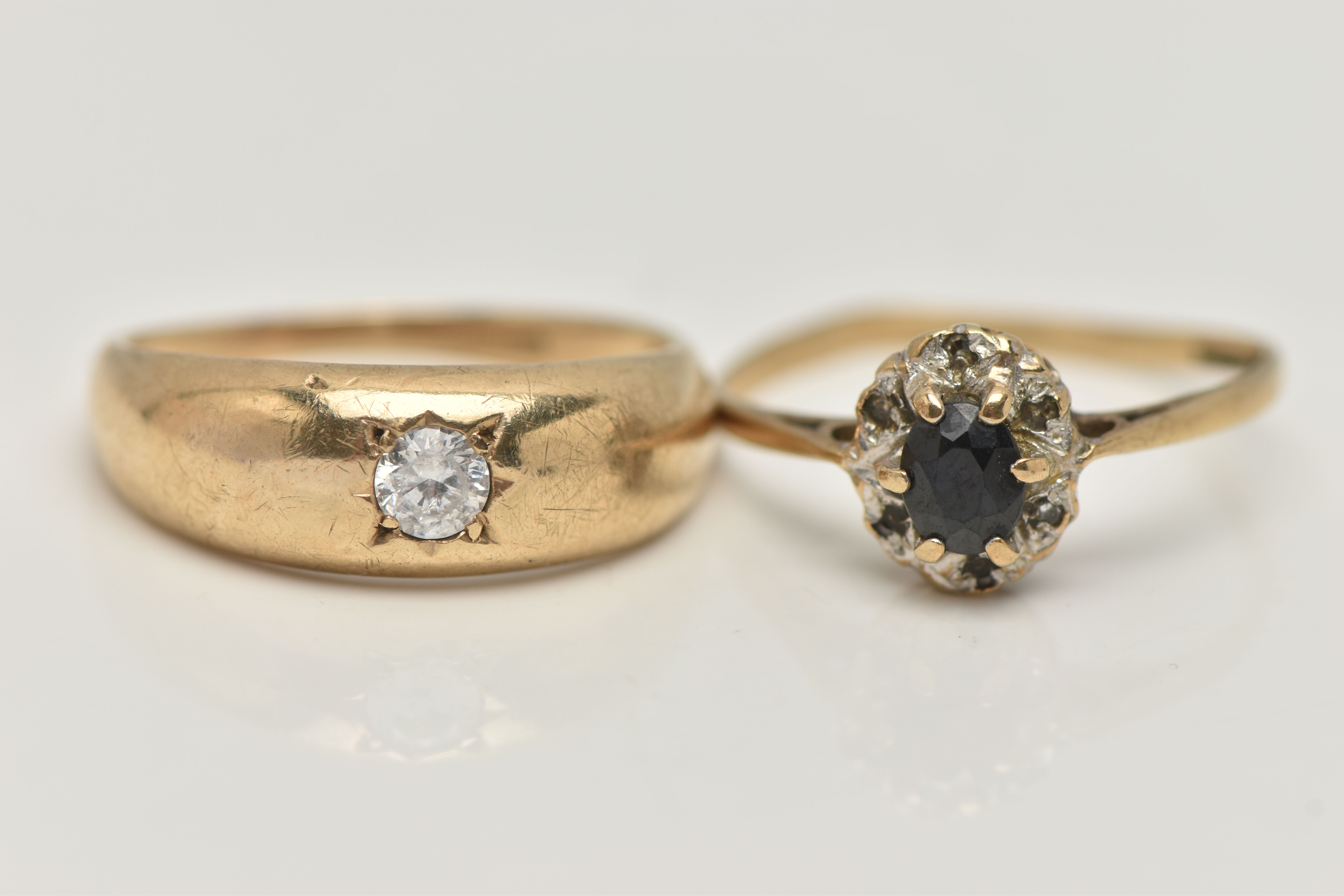 TWO 9CT GOLD RINGS, the first a single circular cut cubic zirconia, star set in a yellow gold