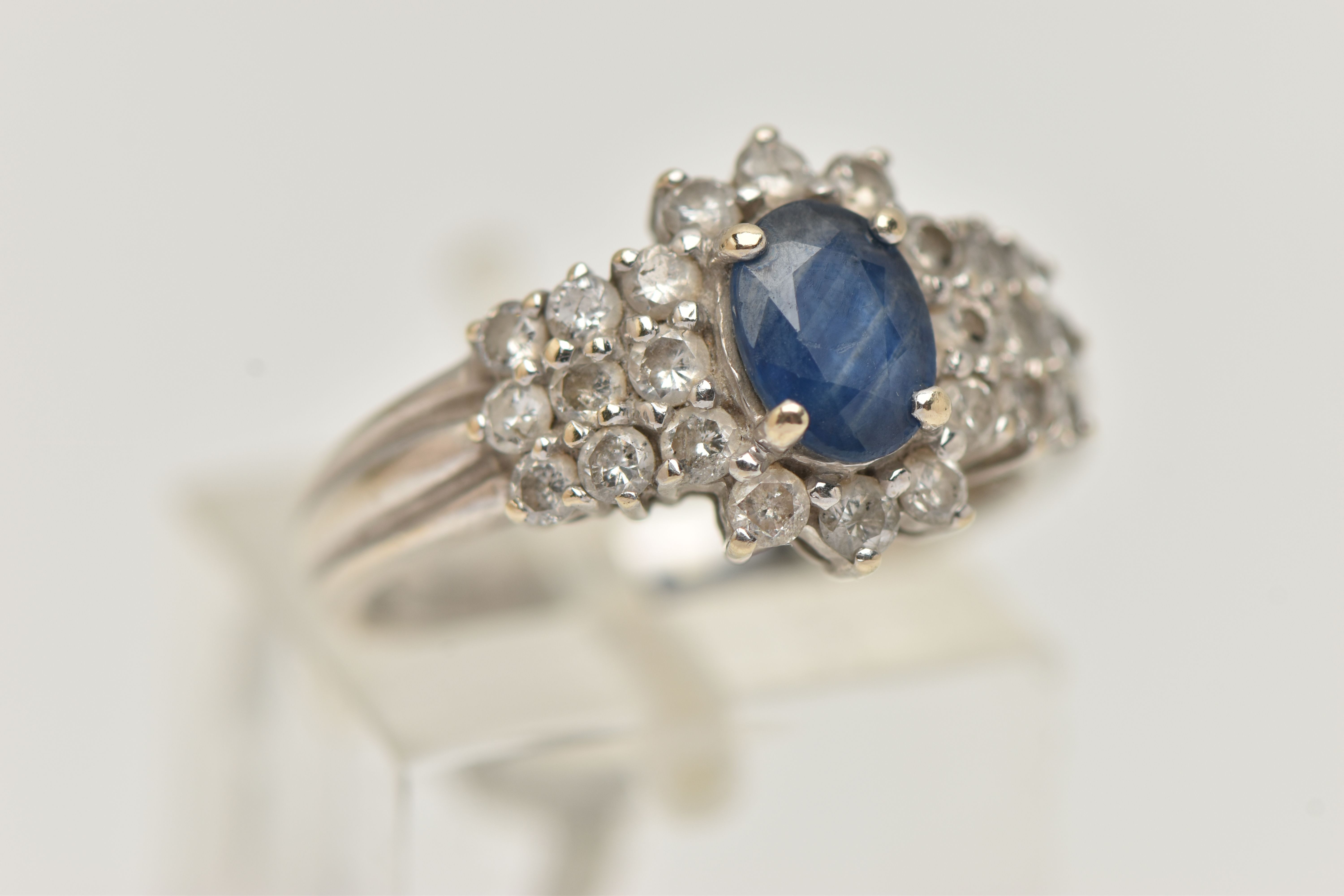 AN 18CT WHITE GOLD SAPPHIRE AND DIAMOND CLUSTER RING, centrally set with an oval cut blue - Image 4 of 4