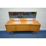 A MID CENTURY TEAK CONCAVE DRESSING TABLE, with a rectangular mirror, fitted with six drawers,