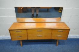 A MID CENTURY TEAK CONCAVE DRESSING TABLE, with a rectangular mirror, fitted with six drawers,