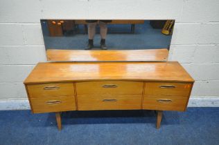 A MID CENTURY TEAK CONCAVE DRESSING TABLE, with a rectangular mirror, fitted with six drawers,