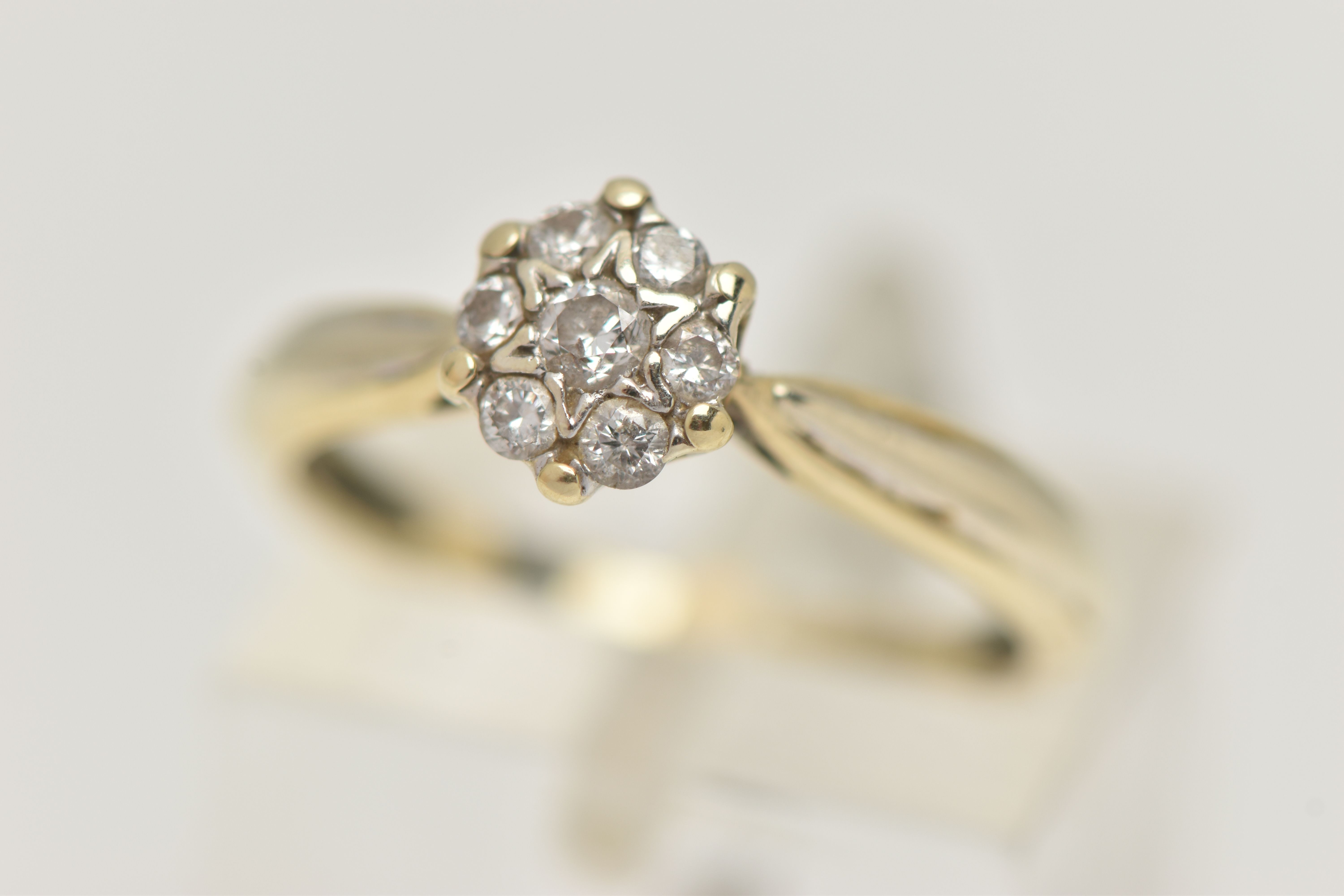 A 9CT GOLD DIAMOND CLUSTER RING, small circular cluster set with seven round brilliant cut diamonds,