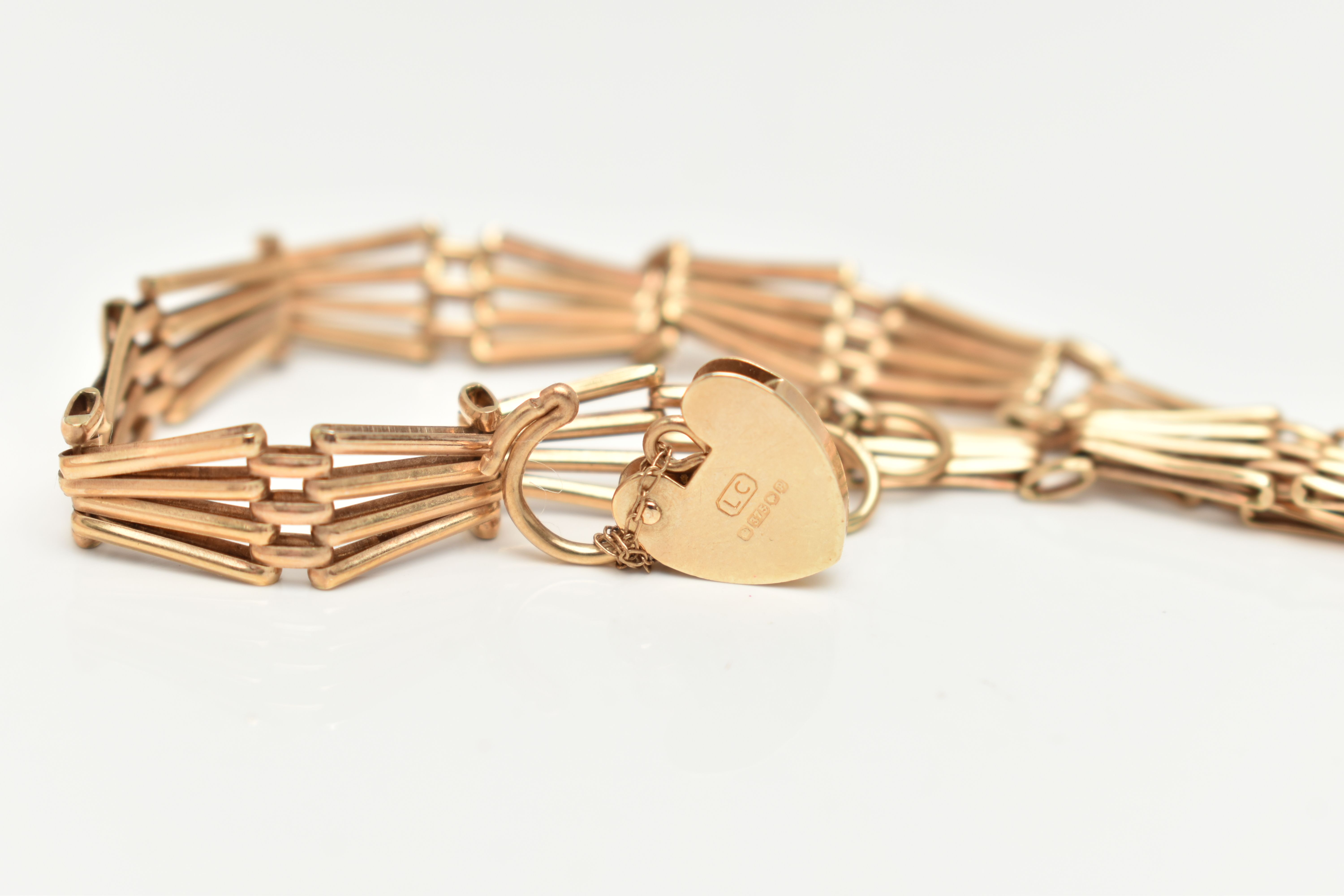 A 9CT YELLOW GOLD BRACELET WITH PADLOCK CLASP, the plain polished abstract design four row gate - Image 2 of 2