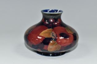 A MOORCROFT 'POMEGRANATE' DESIGN SQUAT VASE, purple pomegranate on a dark blue ground, height 7cm,