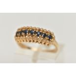 A 9CT GOLD SAPPHIRE RING, seven circular cut sapphires prong set in yellow gold, hallmarked 9ct