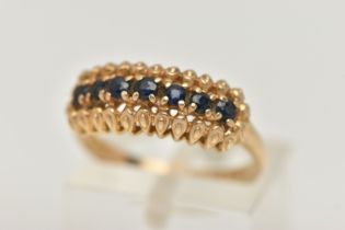 A 9CT GOLD SAPPHIRE RING, seven circular cut sapphires prong set in yellow gold, hallmarked 9ct