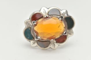 A WHITE METAL HARDSTONE SCOTTISH BROOCH, of an oval wavy form, set with a large oval cut orange