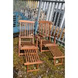 A PAIR OF FOLDING TEAK STEAMER CHAIRS with slatted seat, back and leg rest, brass fittings