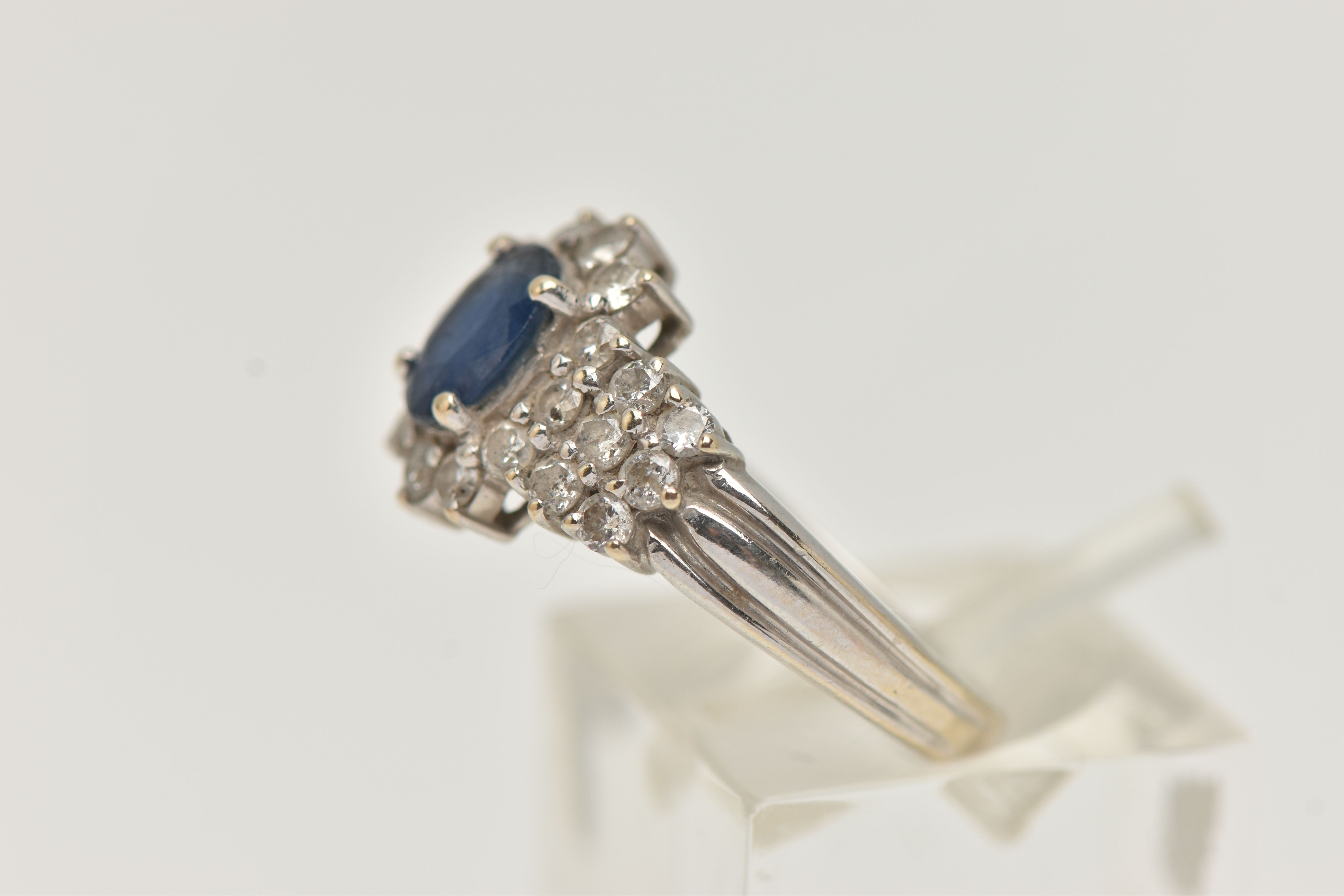 AN 18CT WHITE GOLD SAPPHIRE AND DIAMOND CLUSTER RING, centrally set with an oval cut blue - Image 2 of 4