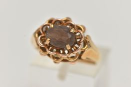 A YELLOW METAL SMOKY QUARTZ RING, set with an oval cut smoky quartz, in a four claw open work