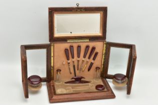AN EARLY 20TH CENTURY TOOLED LEATHER AND GLAZED MANICURE CABINET, the hinged lid with lock and key
