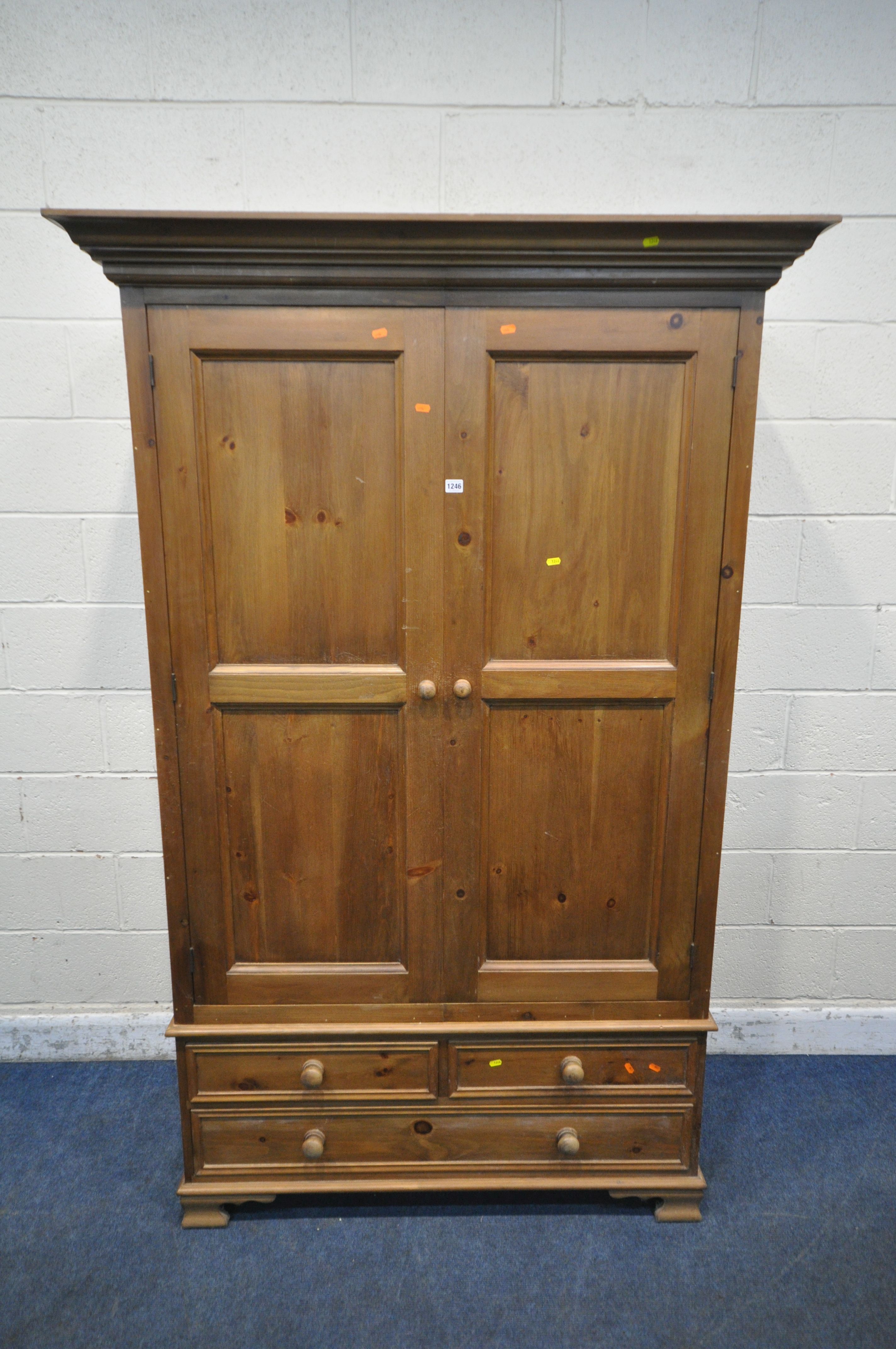 A PINE DOUBLE DOOR WARDROBE, with three drawers, width 130cm x depth 64cm x height 204cm (