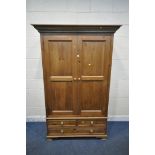 A PINE DOUBLE DOOR WARDROBE, with three drawers, width 130cm x depth 64cm x height 204cm (