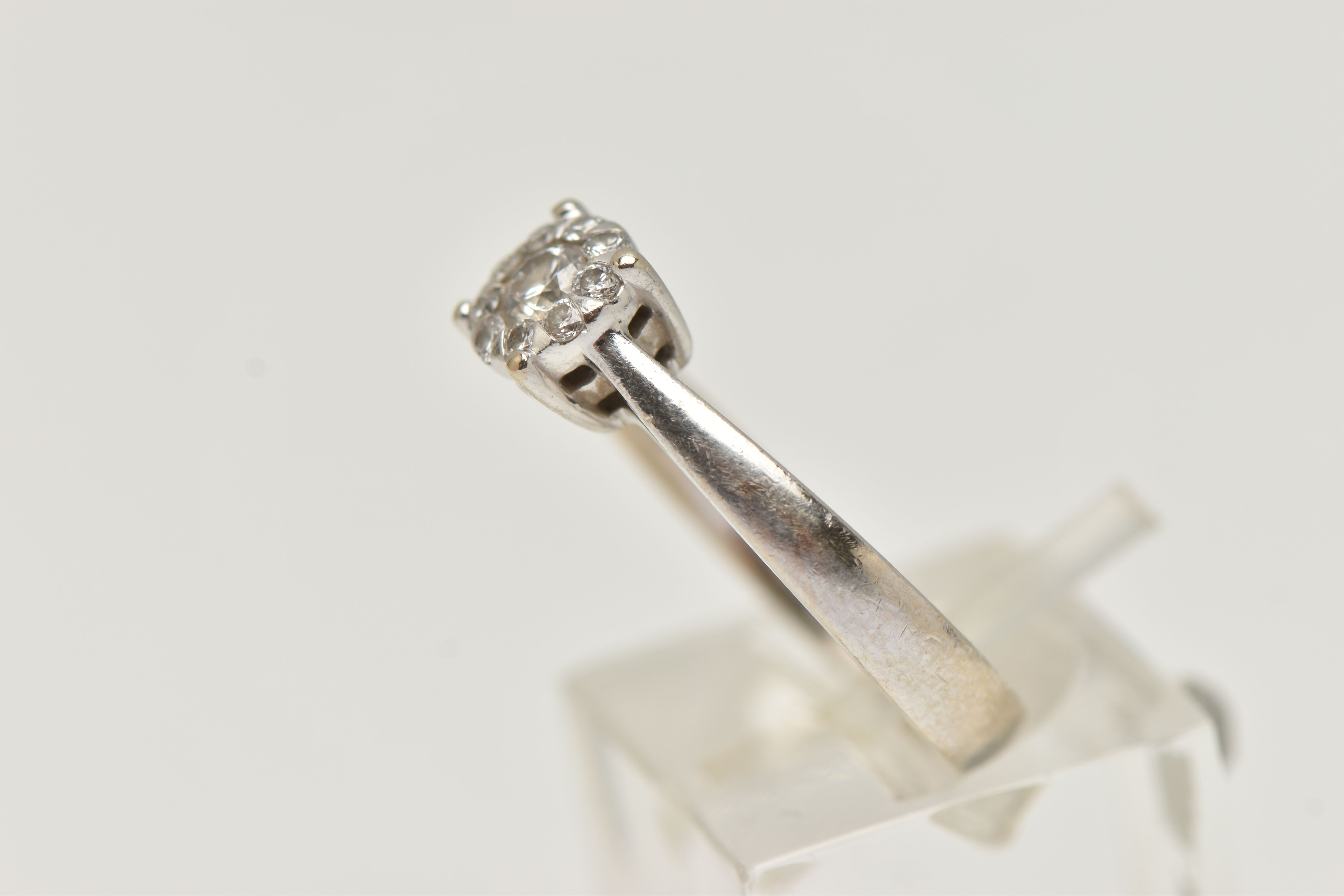 A WHITE METAL DIAMOND CLUSTER RING, centrally set with a round brilliant cut diamond, in a - Image 2 of 4