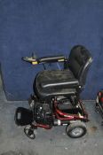 A ROMA ELECTRIC WHEEL CHAIR in red (SPARES OR REPAIRS) with battery and charger (doesn't appear to