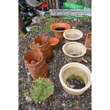 A COLLECTION OF NINE GARDEN POTS including a pair of terracotta chimney pots 47cm high, a pair of