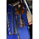 A CASED VIOLIN, two piece back, ebonized fingerboard, in a hard fitted case with two bows - one