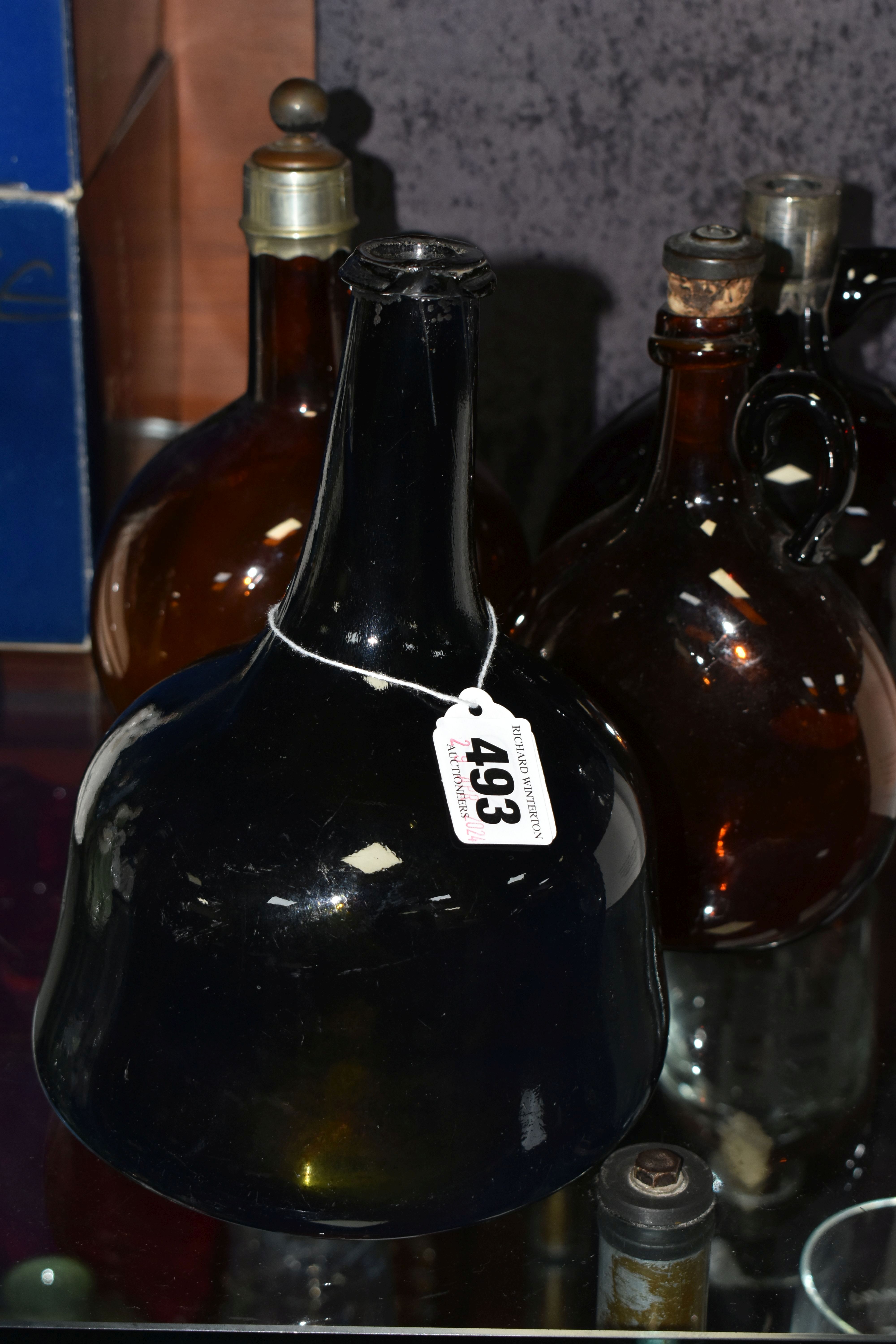 AN 18TH CENTURY MALLET SHAPED AMBER COLOURED BOTTLE, approximate height 21cm, together with three