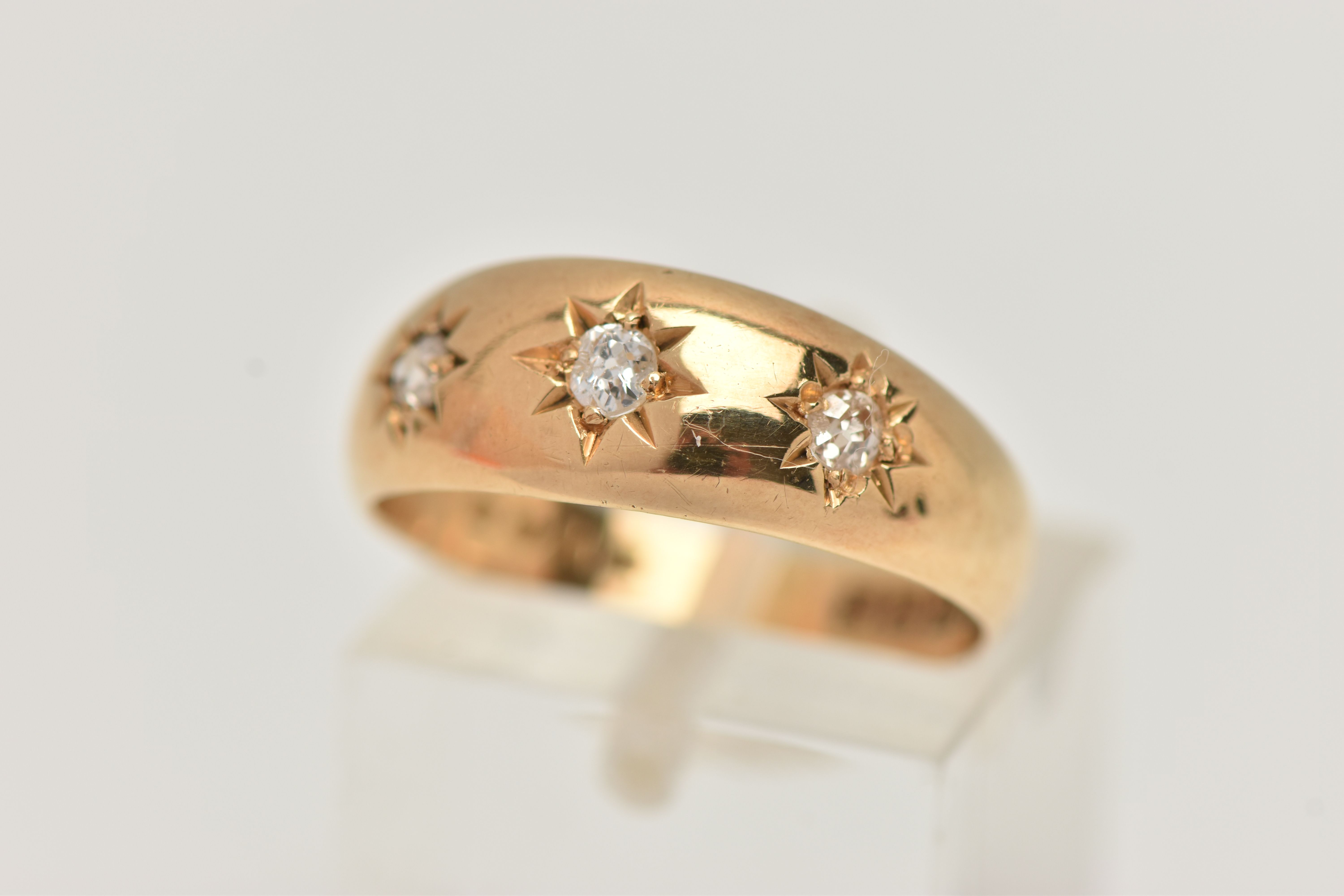 AN EARLY 20TH CENTURY 18CT YELLOW GOLD DIAMOND THREE STONE RING, set with graduating old European
