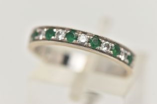A WHITE METAL EMERALD AND DIAMOND HALF ETERNITY RING, set with seven circular cut emeralds,