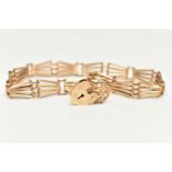 A 9CT YELLOW GOLD BRACELET WITH PADLOCK CLASP, the plain polished abstract design four row gate