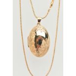 A 9CT GOLD OVAL LOCKET WITH CHAIN, floral pattern to the front, hinged locket opens to reveal two