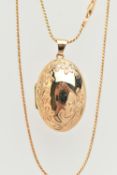 A 9CT GOLD OVAL LOCKET WITH CHAIN, floral pattern to the front, hinged locket opens to reveal two