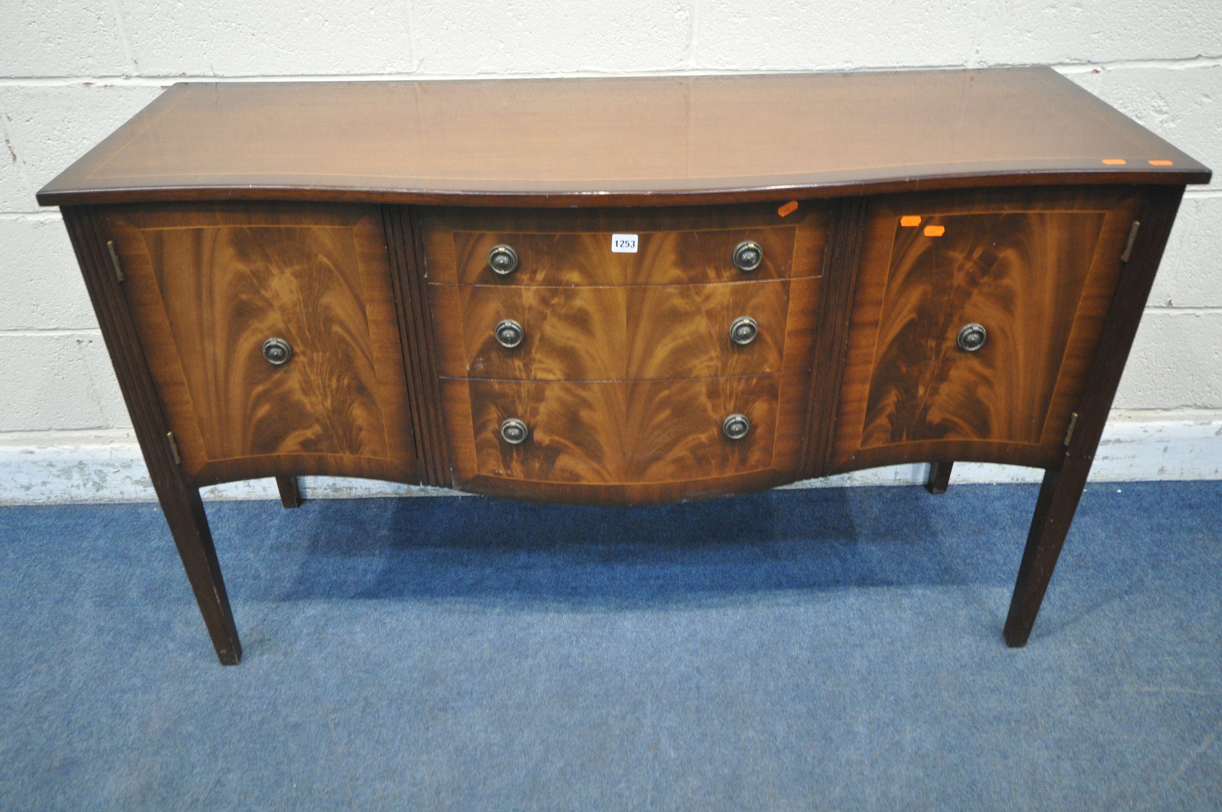 A REPRODUCTION MAHOGANY SERPENTINE SIDEBOARD, fitted with two cupboard doors, flanking three