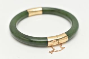 A NEPHRITE JADE BANGLE, with fittings to the hinge and clasp, safety chain attached, clasp stamped