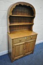 A 20TH CENTURY OAK DRESSER, the arched top with a two tier plate rack, atop a base with two