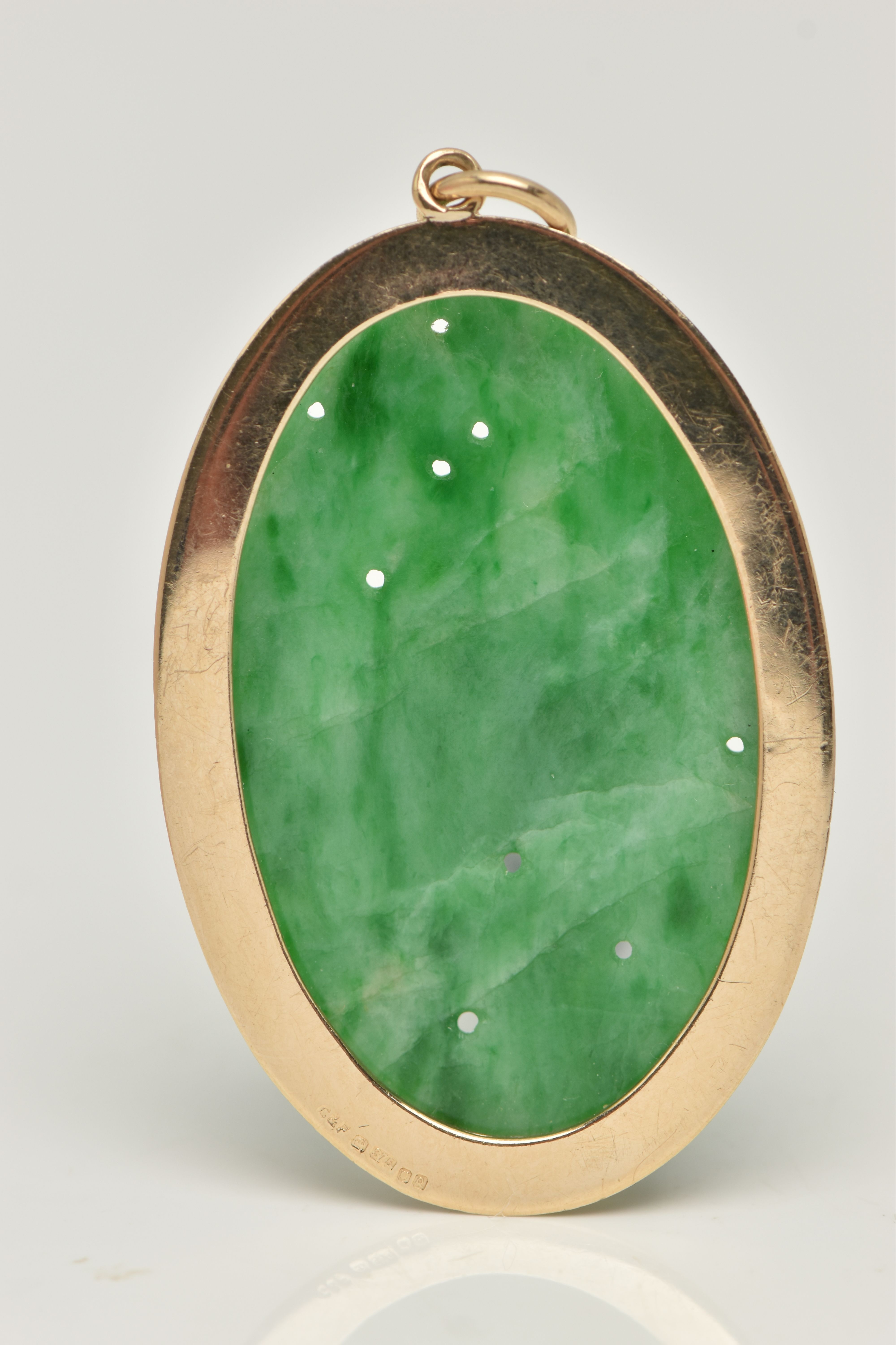 A 9CT GOLD CARVED JADE PENDANT, the oval jade panel carved to depict flowers, foliage and possibly - Image 2 of 4