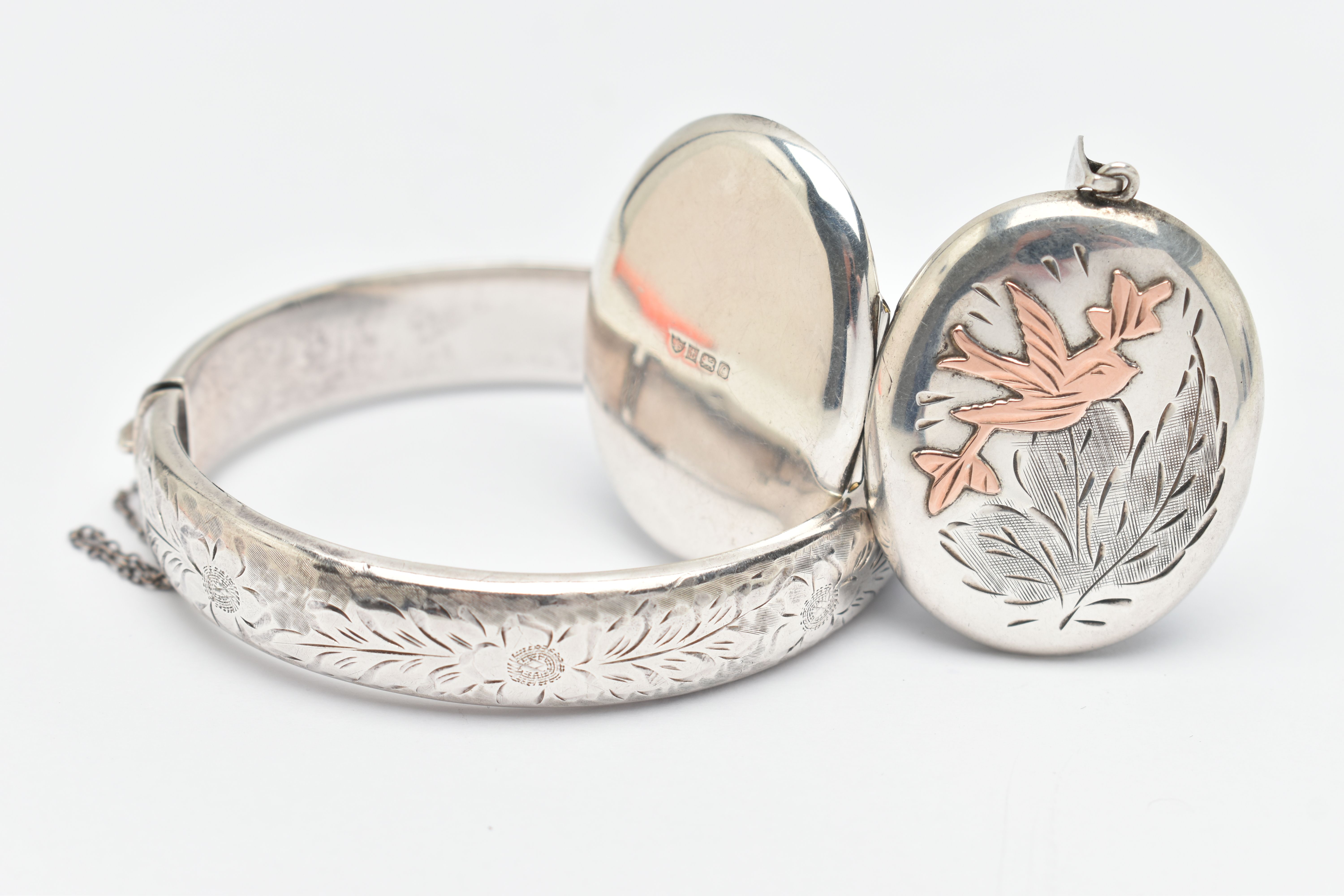 A SILVER HINGED BANGLE AND LOCKET, the bangle with floral pattern, fitted with a push piece