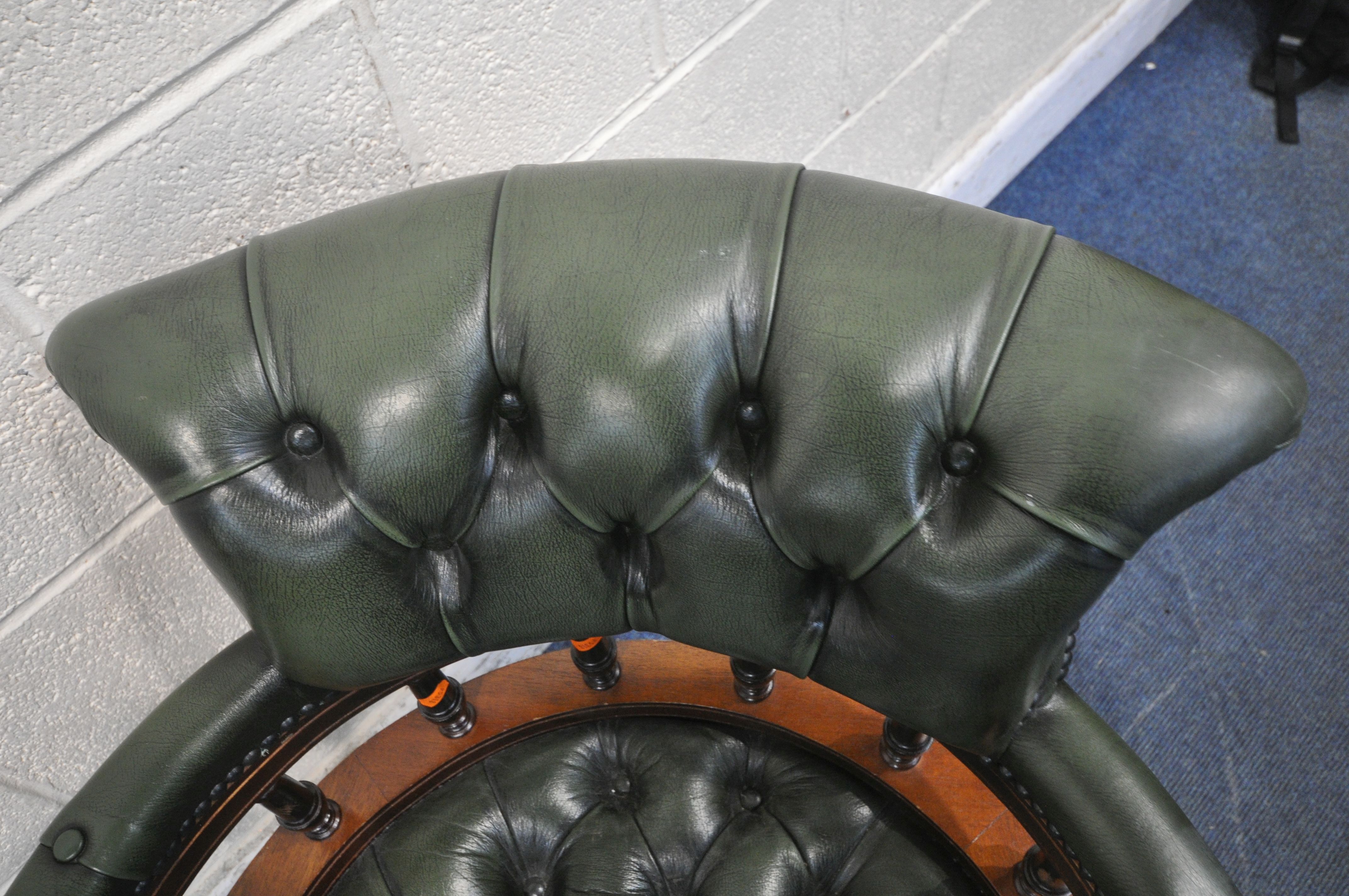 A 2OTH CENTURY MAHOGANY SWIVEL CAPTAINS CHAIR, with buttoned green leather upholstery, raised on - Image 2 of 4