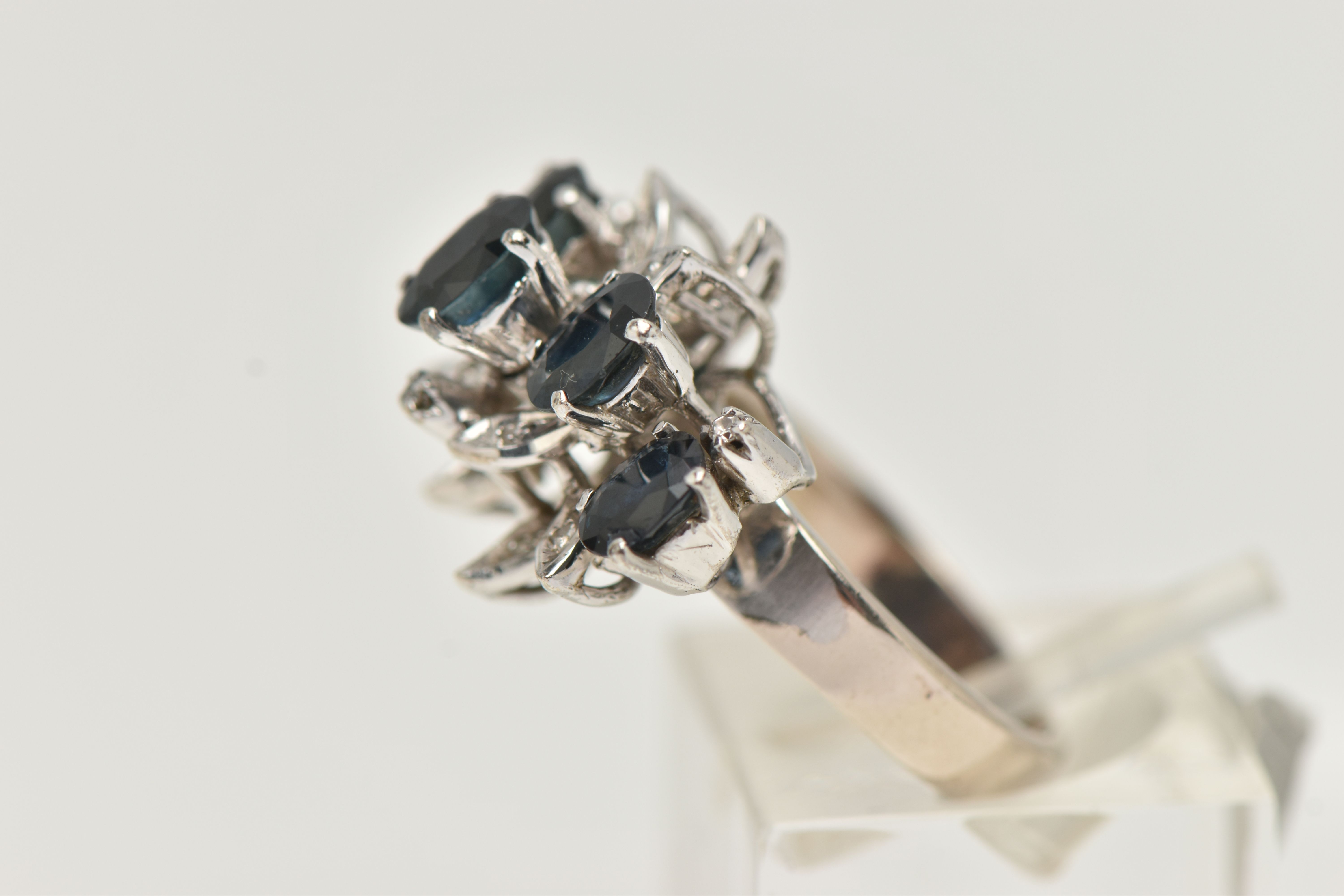 A WHITE METAL SAPPHIRE AND DIAMOND DRESS RING, set with five oval cut blue sapphires, single cut - Image 2 of 4