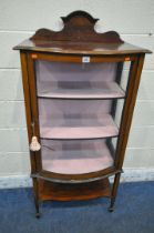 AN EDWARDIAN MAHOGANY BOW FRONT DISPLAY CABINET, with a raised back, the single door enclosing two