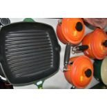 LE CREUSET KITCHEN WARE IN GREEN AND ORANGE, comprising a set of three orange saucepans with lids in