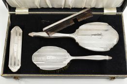 A CASED FOUR PIECE SILVER VANITY SET, to include a hair brush, hand held mirror, clothes brush and a