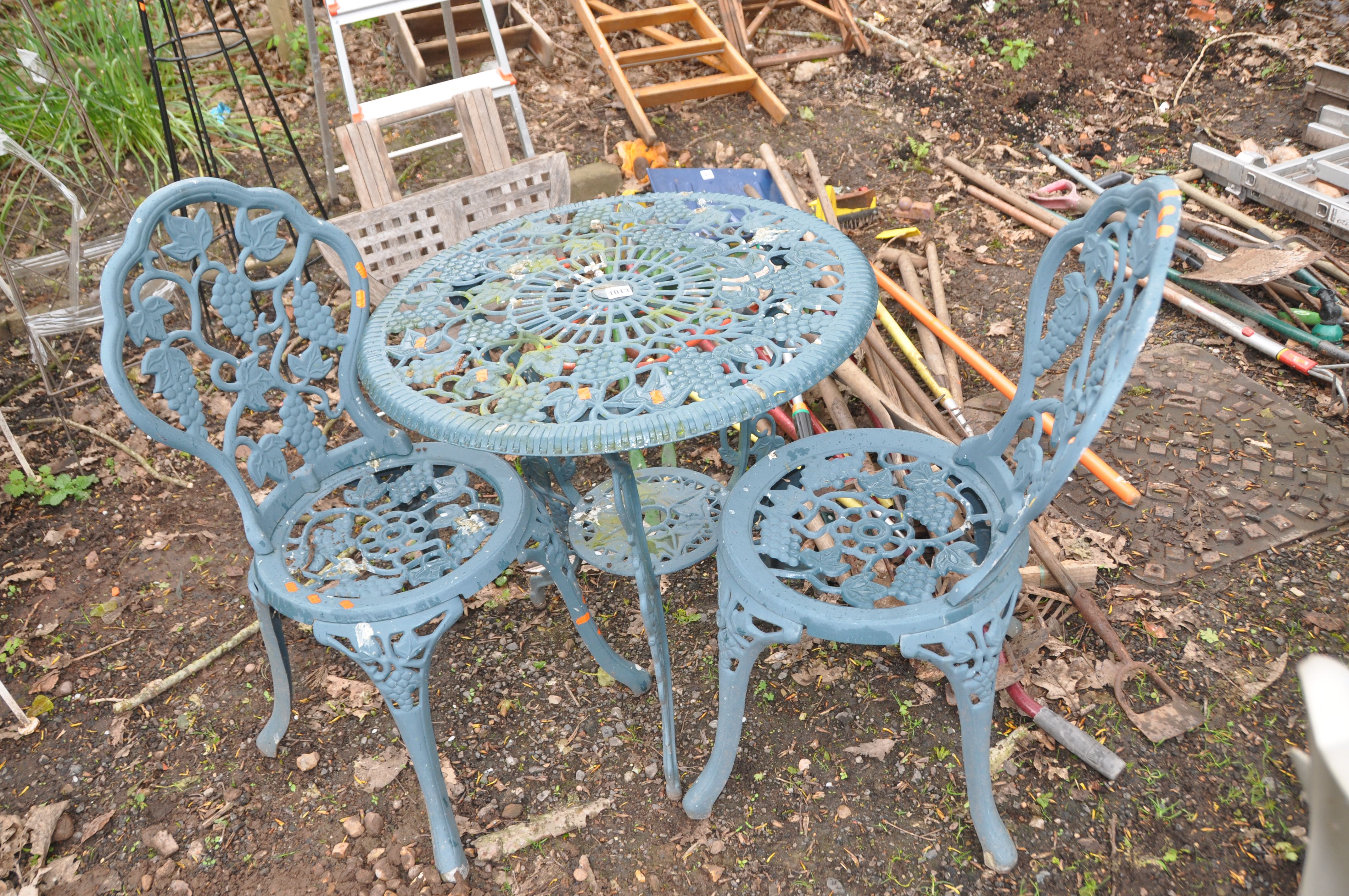 A CAST ALUMINIUM GARDEN TABLE 67cm in diameter, and a pair of matching chairs with grape and vine