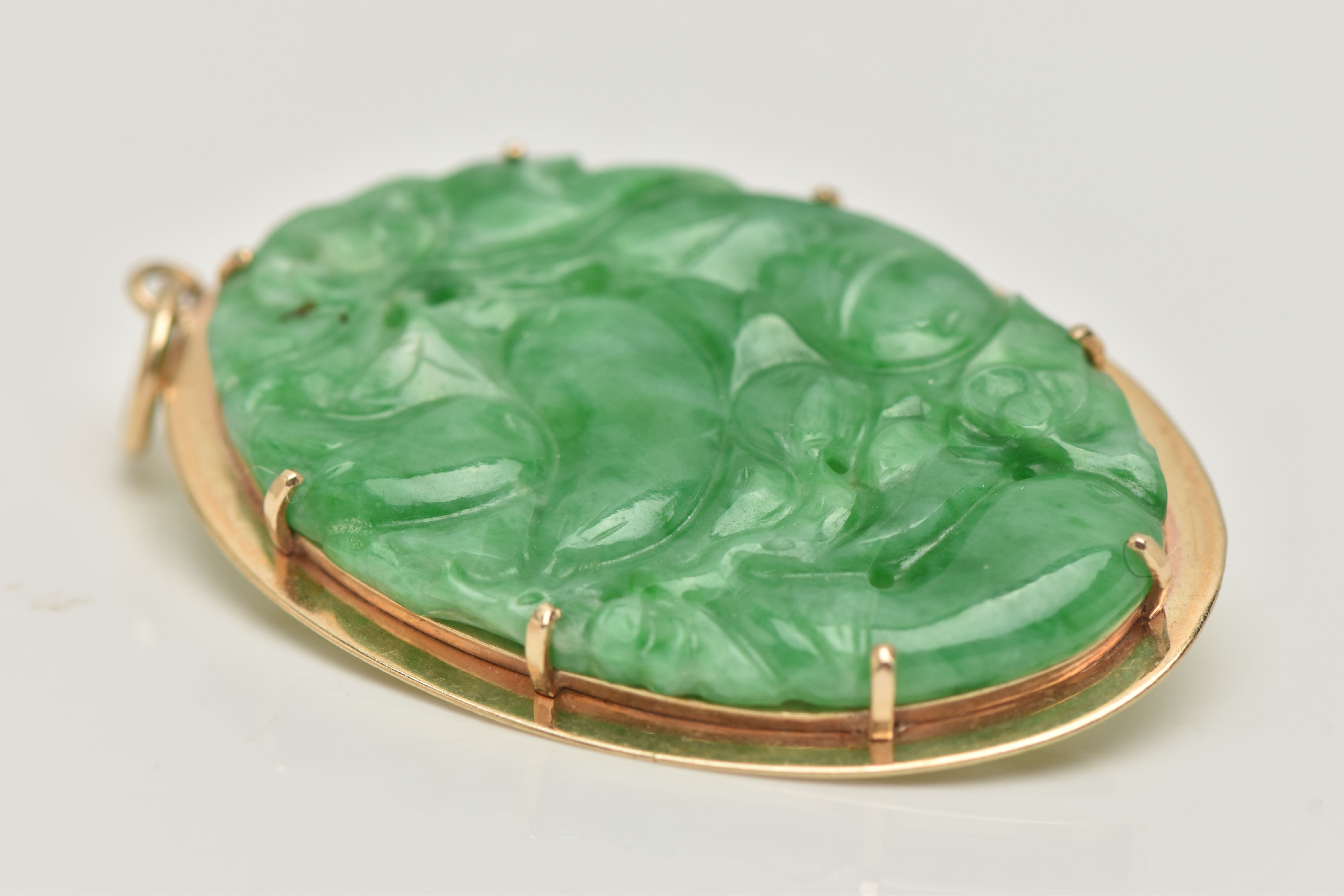 A 9CT GOLD CARVED JADE PENDANT, the oval jade panel carved to depict flowers, foliage and possibly - Image 4 of 4