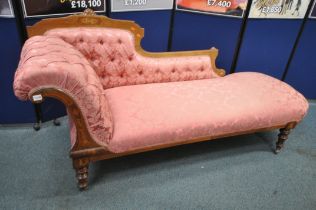 A LATE VICTORIAN WALNUT AND INLAID CHAISE LOUNGE, with pink and floral upholstery, raised on