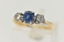 A YELLOW METAL SAPPHIRE AND DIAMOND RING, centering on an oval cut, deep blue sapphire, flanked by