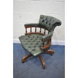 A 2OTH CENTURY MAHOGANY SWIVEL CAPTAINS CHAIR, with buttoned green leather upholstery, raised on