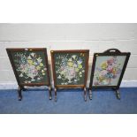 THREE VARIOUS 20TH CENTURY OAK FIRE SCREENS, all with floral needlework inserts, largest width