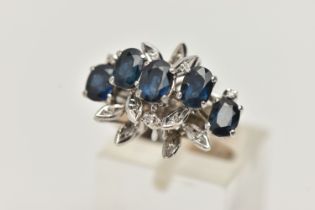A WHITE METAL SAPPHIRE AND DIAMOND DRESS RING, set with five oval cut blue sapphires, single cut
