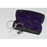 A PAIR OF EARLY 20TH CENTURY YELLOW METAL SPECTACLE GLASSES WITH CASE, the spectacles with plain