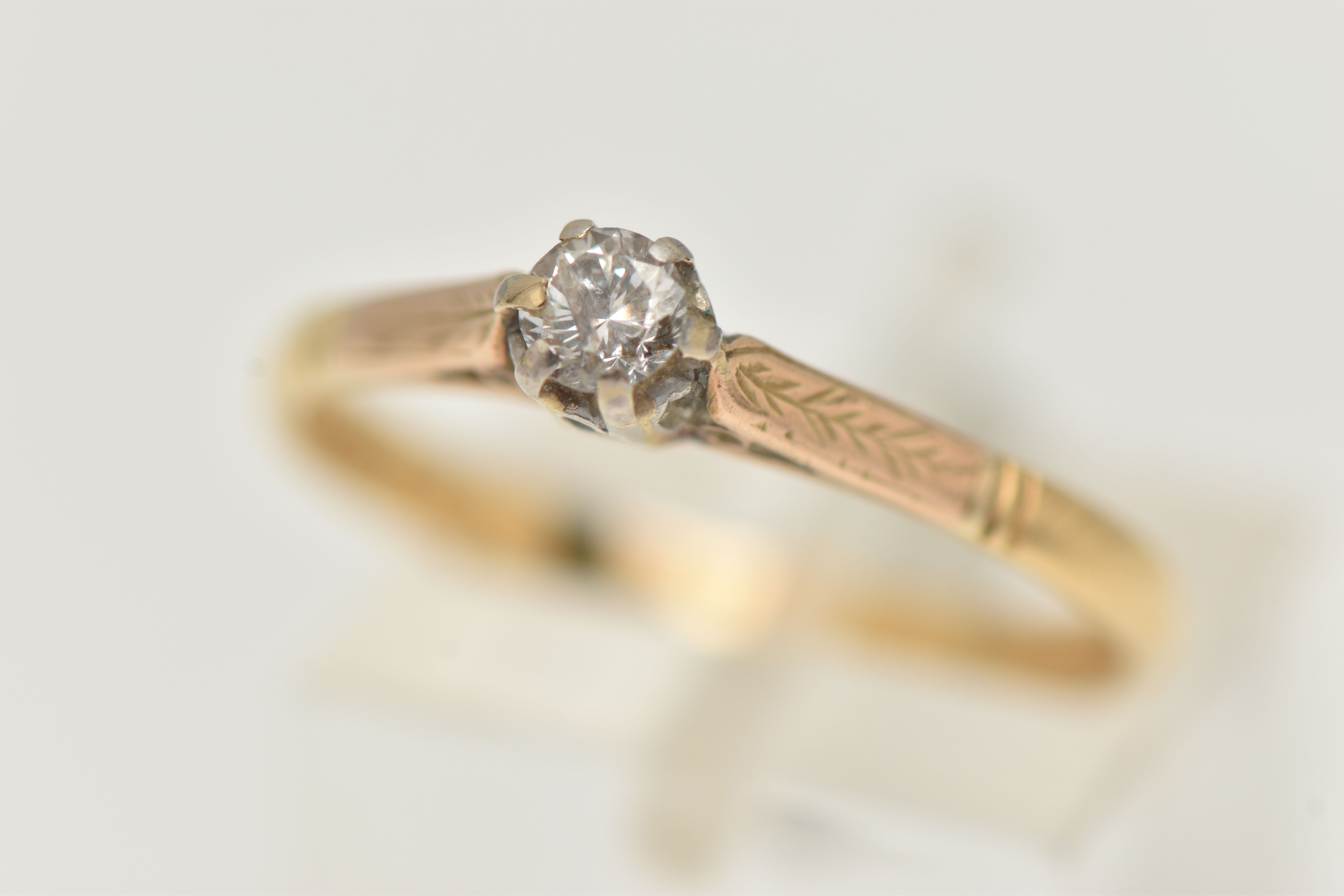 A YELLOW METAL DIAMOND SINGLE STONE RING, set with a round brilliant cut diamond, claw set,