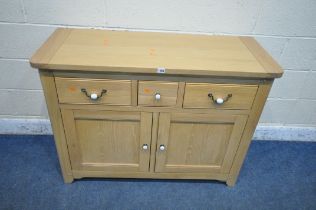 A MODERN LIGHT OAK SIDEBOARD, fitted with three drawers, over double cupboard doors, width 115cm x