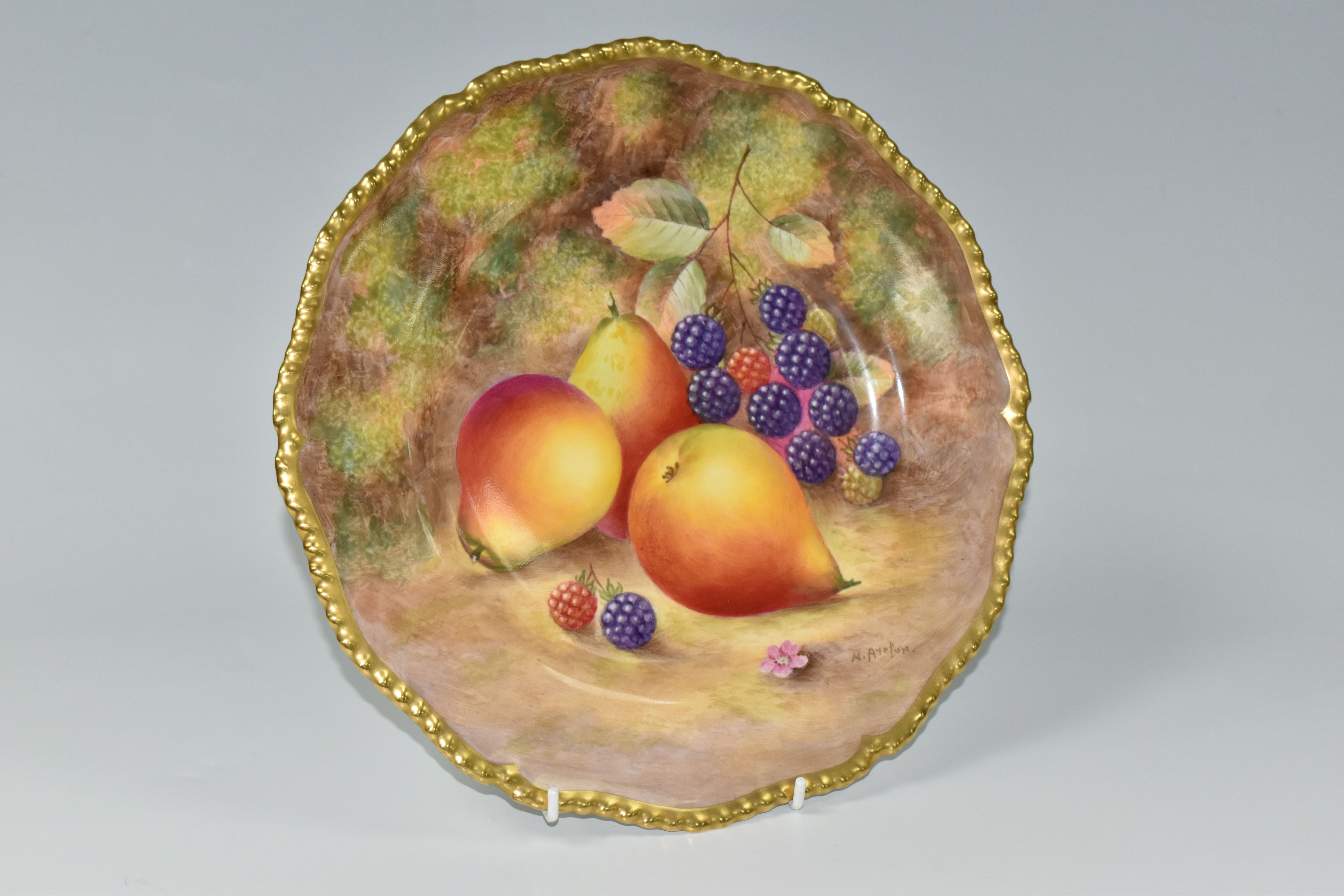 A ROYAL WORCESTER flower shaped cabinet plate, with gilt gadrooned edge, decorated with hand painted
